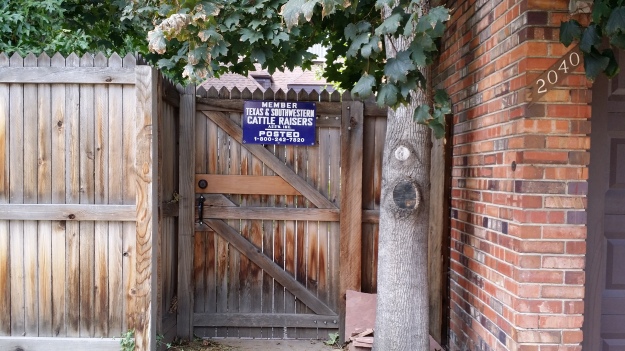 Image:  Wooden fence with a sign reading "Member Texas & Southwestern Cattle Raisers Ass'n Inc.  POSTED. 